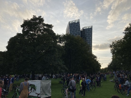 Foto aus dem alten Elbpark. Im Hintergrund die tanzenden Türme am Ende der Reeperbahn. Um Vordergrund eine Menge Leute mit Fahrrädern.